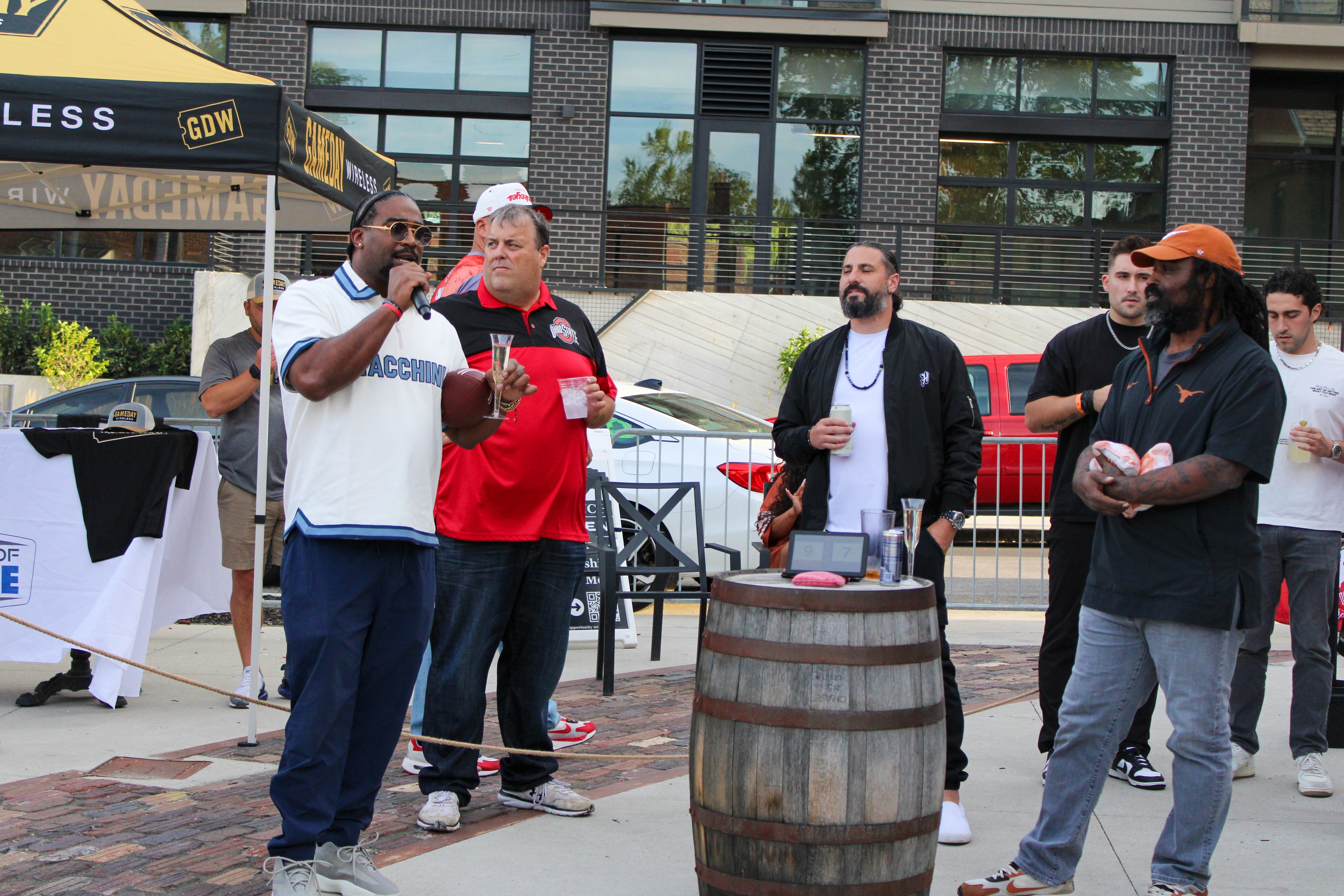 Athletes and emcee on the cornhole court