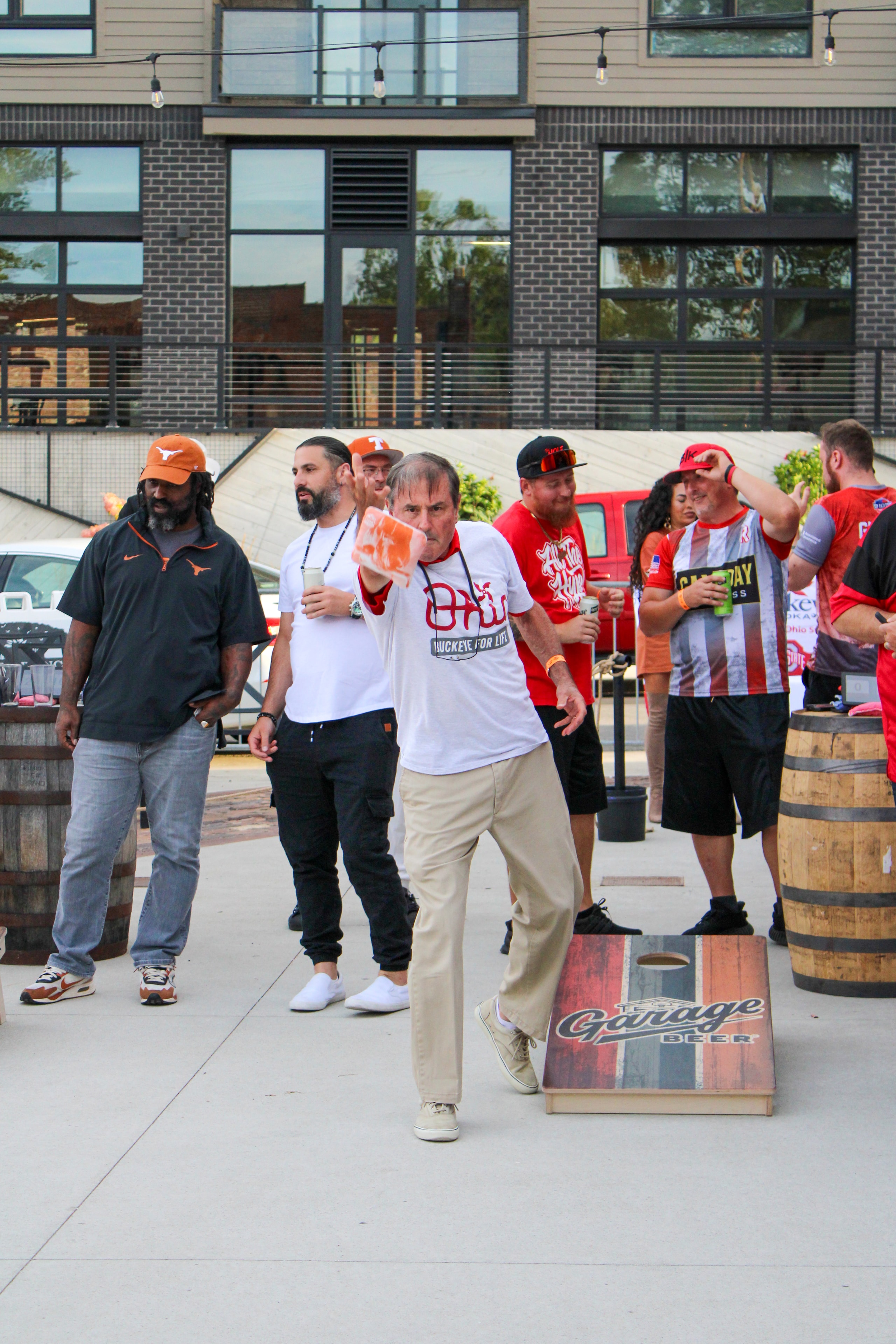 Fan throwing cornhole bag with crowd cheering