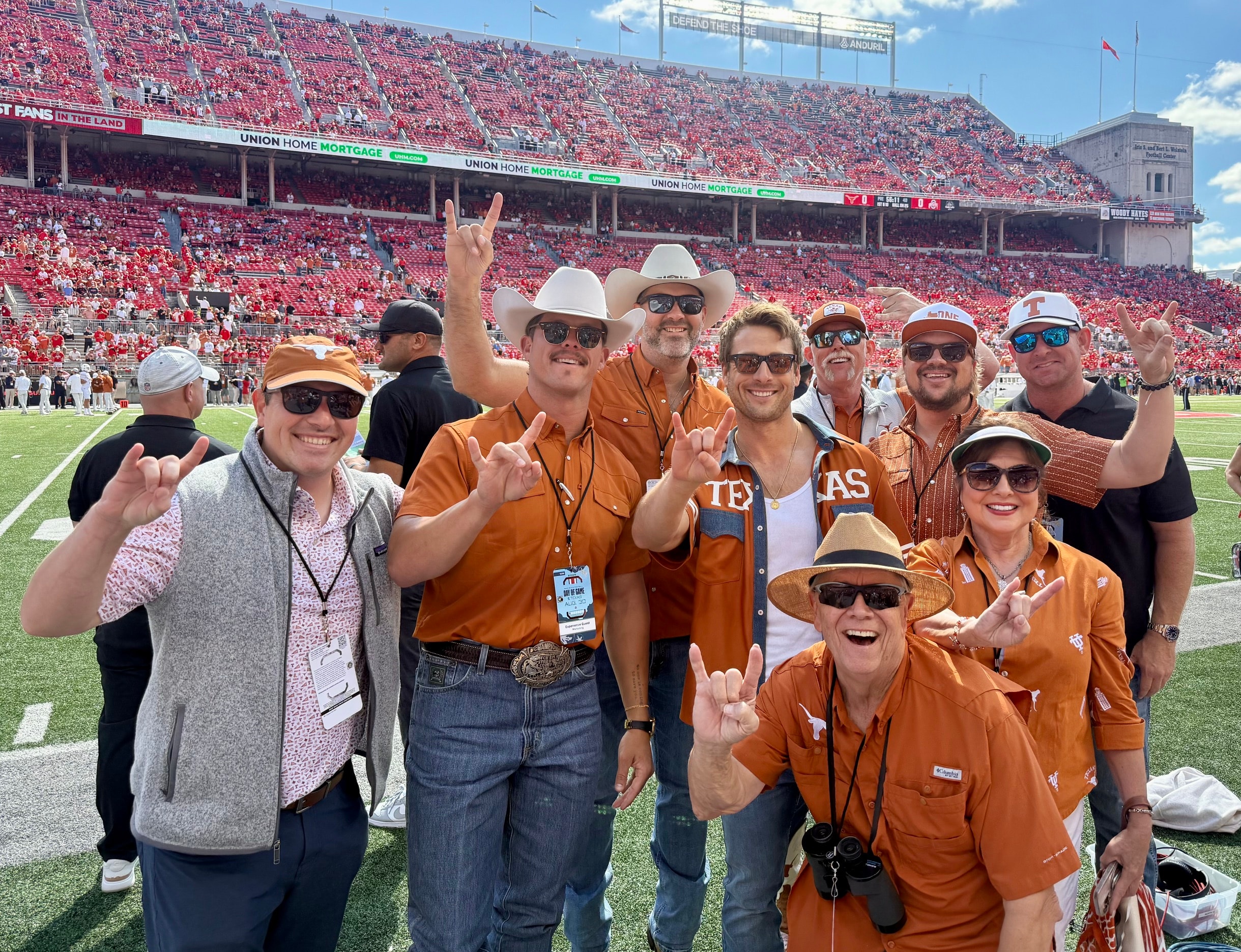 Texas Longhorns fans on the field at Ohio Stadium throwing Hook 'Em horns